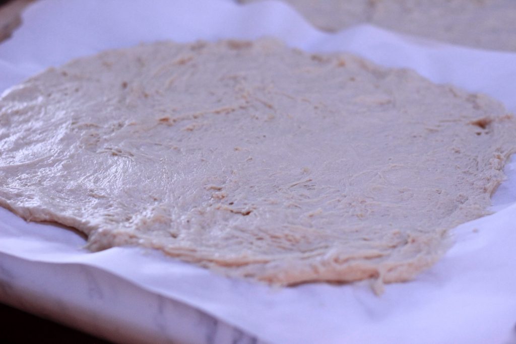 untopped pizza crust on parchment paper