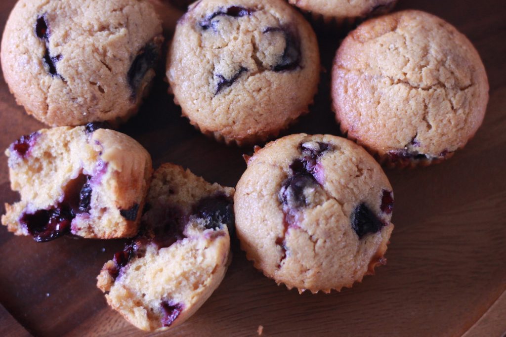 top view of blueberry muffins with one torn in half